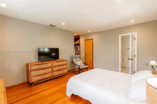 a bedroom with a bed and flat screen tv