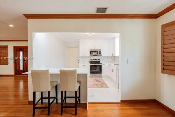 a view of kitchen with microwave and wooden floor