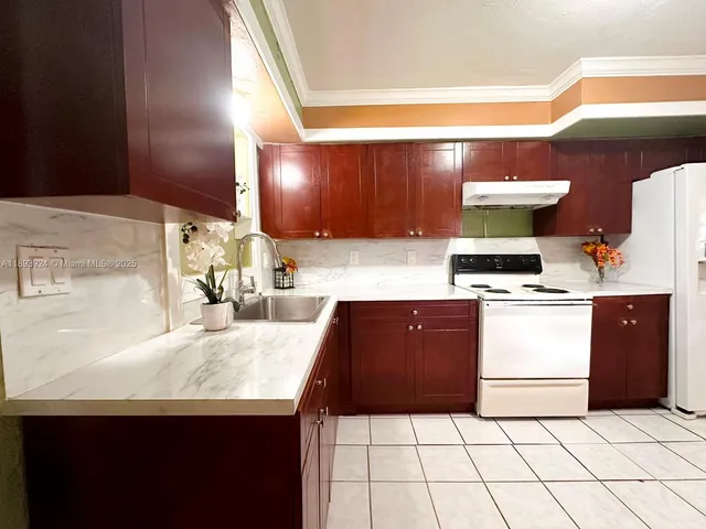 a kitchen with a sink a stove and cabinets