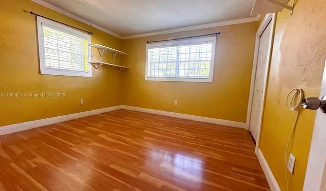 a view of a room with wooden floor and windows