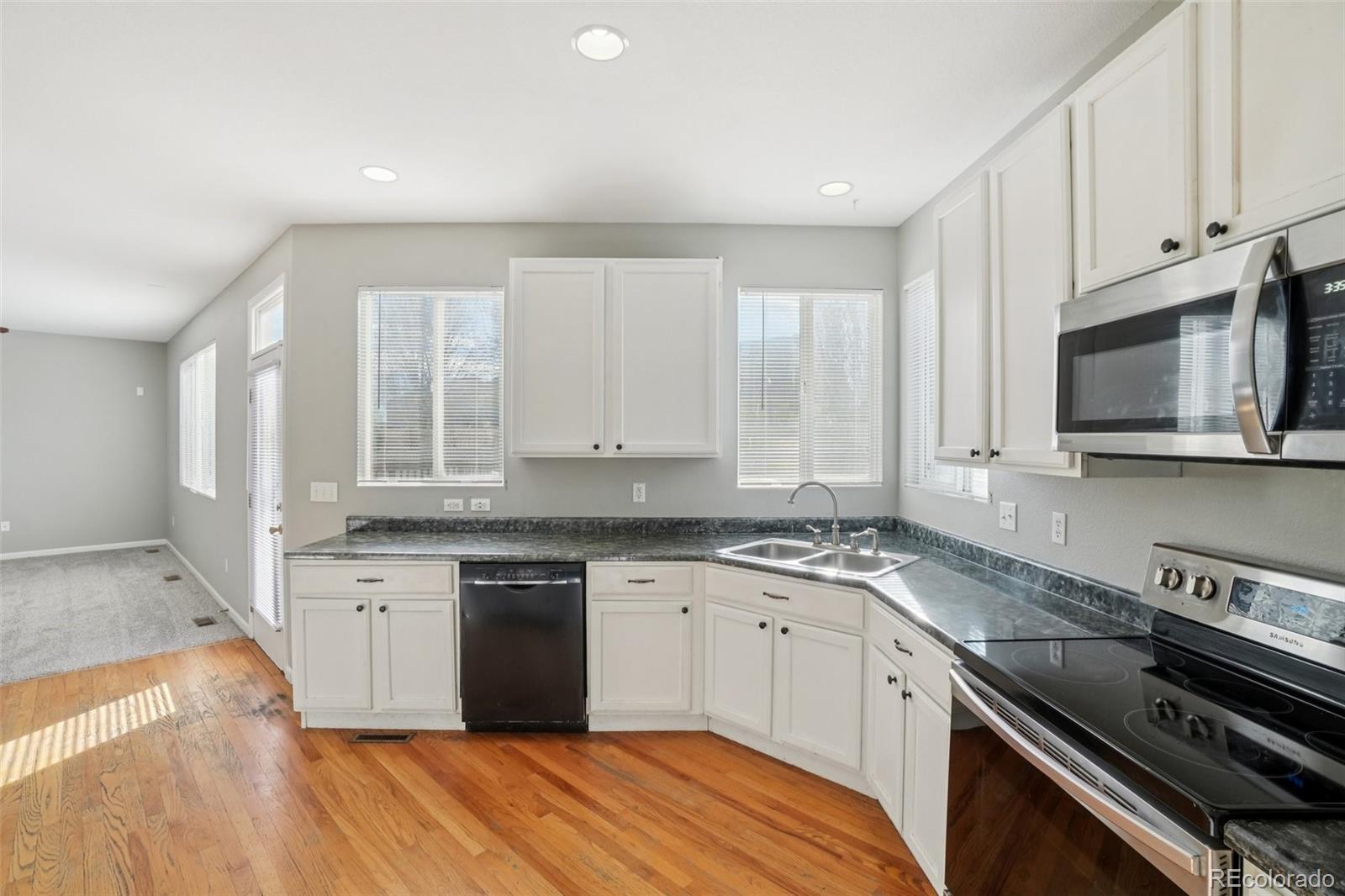 11205 Coal Ridge Street Firestone, CO 80504 - Photo 11 of 40 a kitchen with stainless steel appliances granite countertop a stove a sink and a microwave