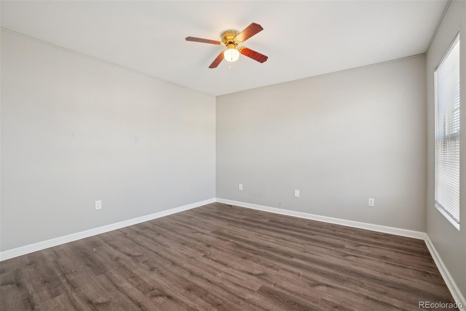 11205 Coal Ridge Street Firestone, CO 80504 - Photo 14 of 40 a view of an empty room with window and a ceiling fan