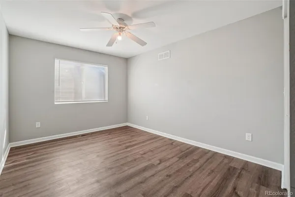 a view of an empty room with wooden floor