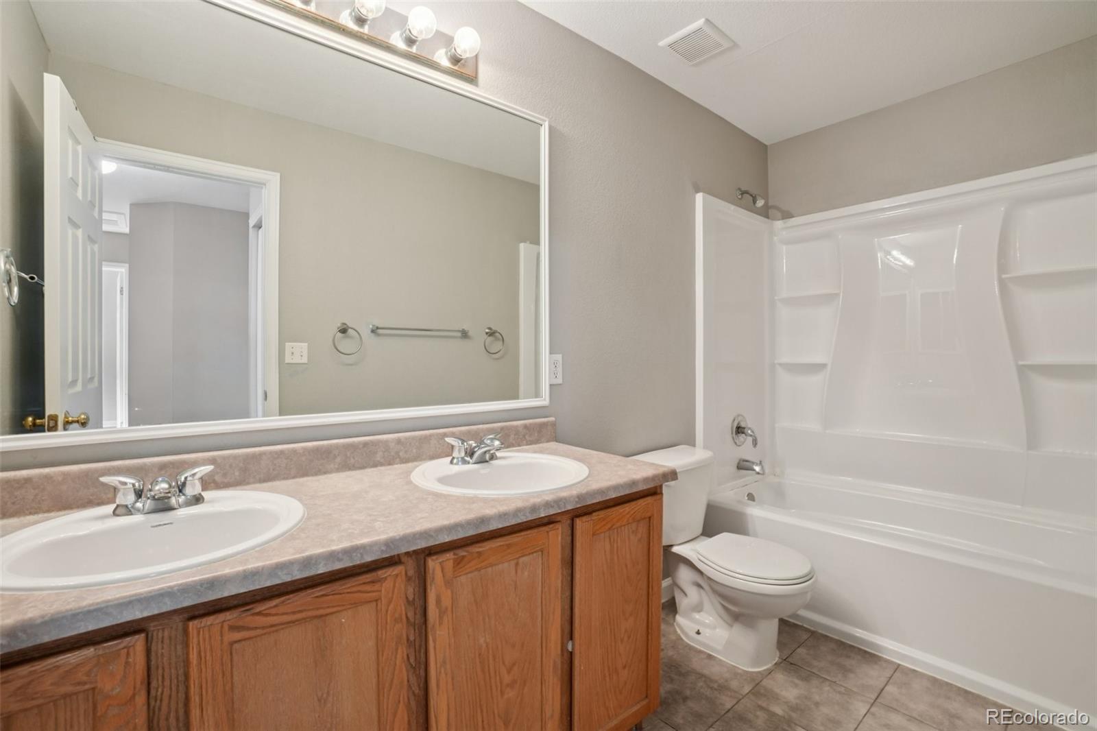 11205 Coal Ridge Street Firestone, CO 80504 - Photo 19 of 40 a bathroom with a granite countertop sink toilet and shower