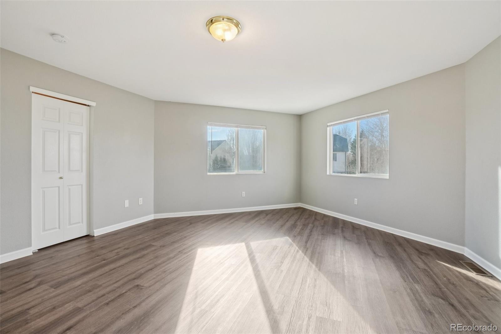 11205 Coal Ridge Street Firestone, CO 80504 - Photo 22 of 40 a view of an empty room with wooden floor and a window