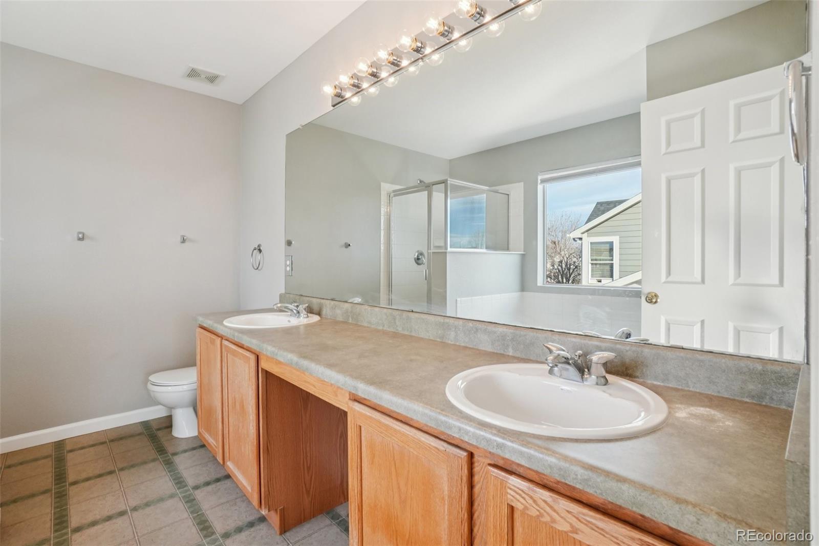 11205 Coal Ridge Street Firestone, CO 80504 - Photo 23 of 40 a bathroom with a sink double vanity and a mirror