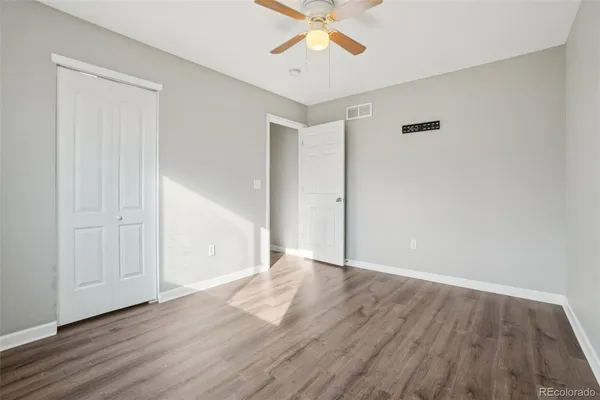 a view of an empty room with wooden floor and stairs