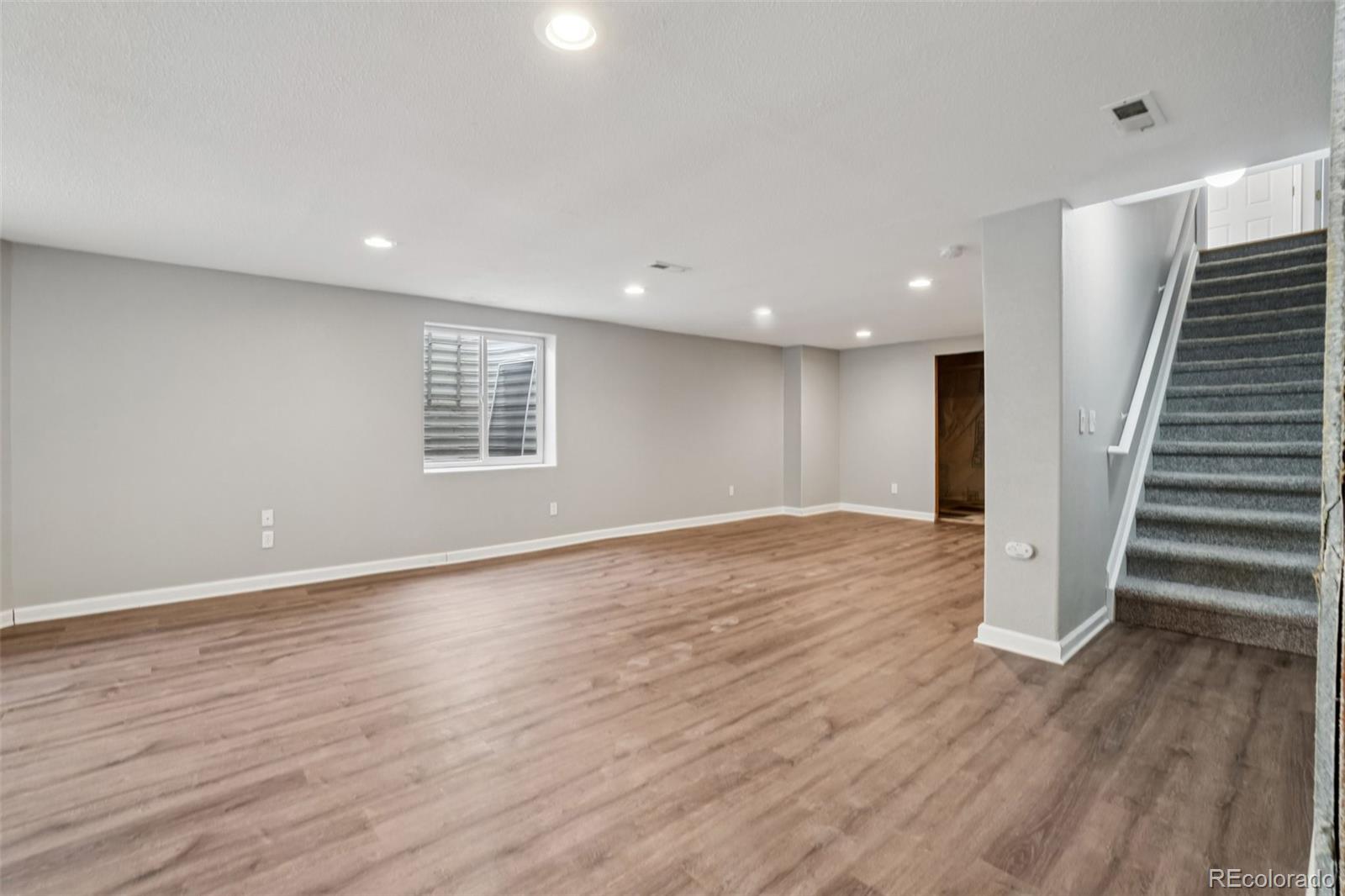 11205 Coal Ridge Street Firestone, CO 80504 - Photo 28 of 40 a view of an empty room with wooden floor and stairs