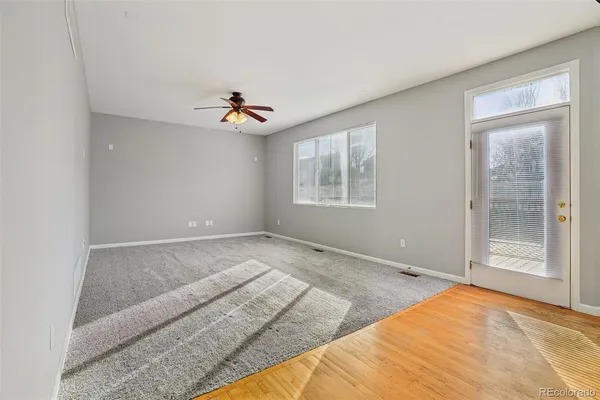 a view of empty room with wooden floor and windows
