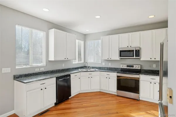 a kitchen with stainless steel appliances granite countertop a stove a sink and a microwave