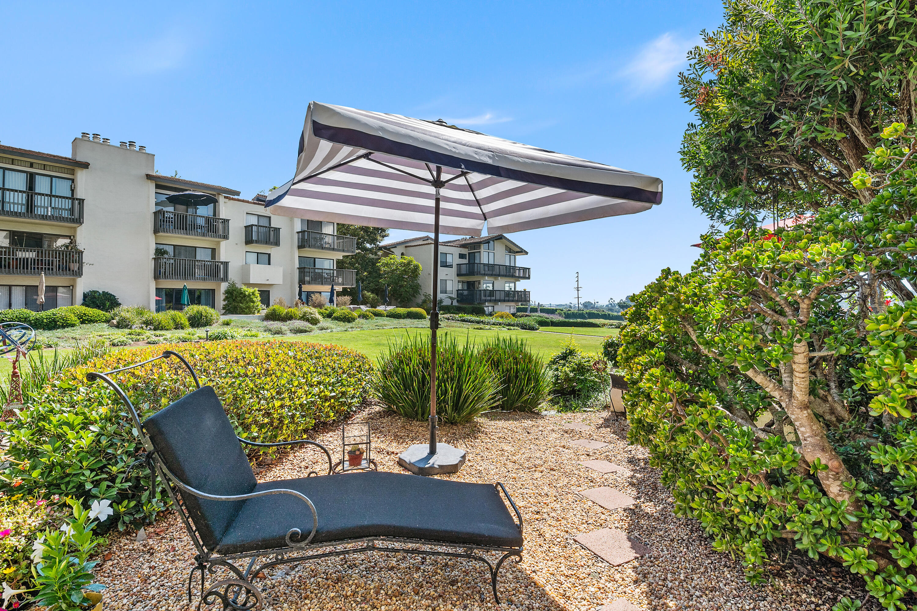 3375 Foothill Road, Unit 412 Carpinteria, CA 93013 - Photo 16 of 22 a view of a patio with couches chairs and a yard
