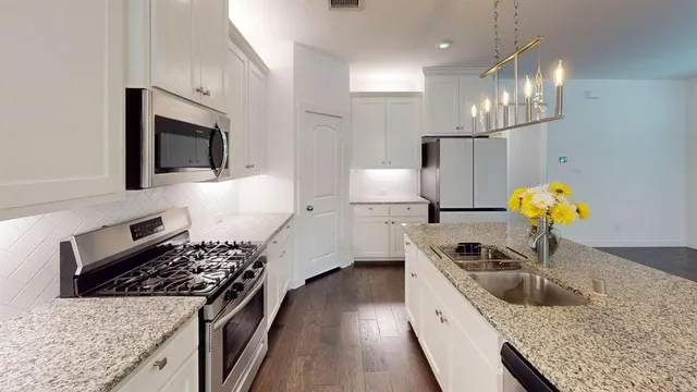 a kitchen with stainless steel appliances granite countertop a sink stove and refrigerator