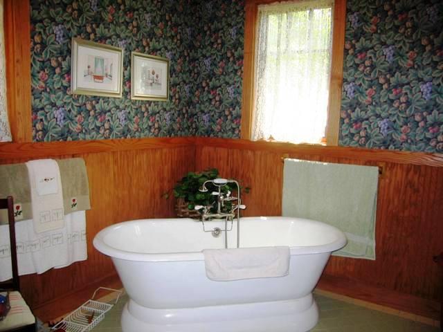 99 Hupi Road Monterey, MA 01245 - Photo 13 of 20 a white bath tub sitting in a bathroom next to a window