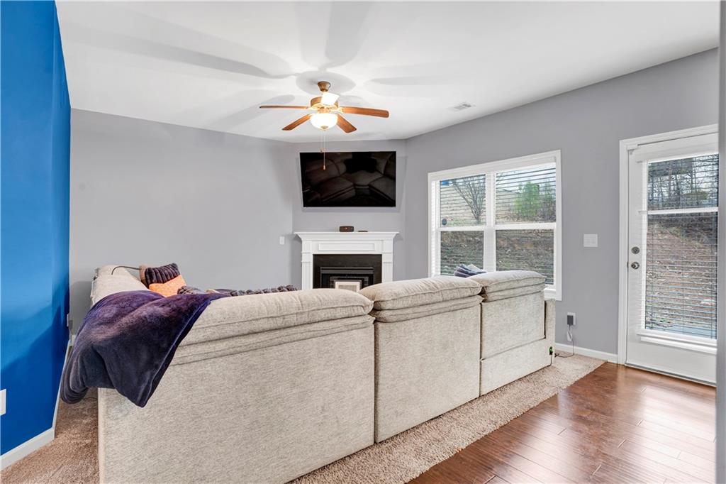 7789 Village Pass Fairburn, GA 30213 - Photo 13 of 35 a living room with furniture a flat screen tv and a fireplace