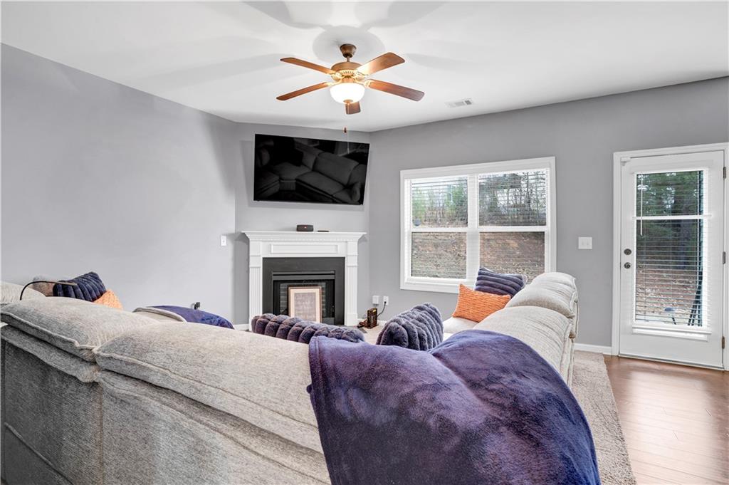 7789 Village Pass Fairburn, GA 30213 - Photo 14 of 35 a living room with furniture a fireplace and a flat screen tv