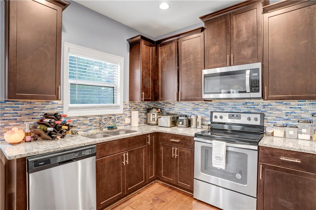 7789 Village Pass Fairburn, GA 30213 - Photo 18 of 35 a kitchen with stainless steel appliances a sink stove and microwave