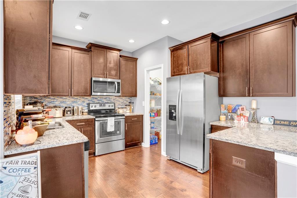 7789 Village Pass Fairburn, GA 30213 - Photo 20 of 35 a kitchen with stainless steel appliances granite countertop a refrigerator stove microwave and sink