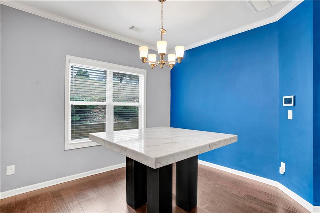 7789 Village Pass Fairburn, GA 30213 - Photo 10 of 35 a room that has a dining table and a chandelier