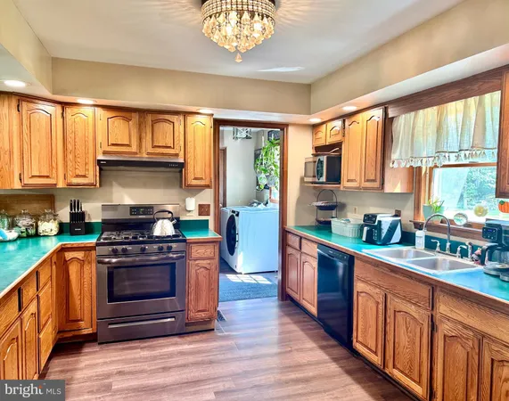 a kitchen with stainless steel appliances granite countertop a stove a sink dishwasher and a refrigerator