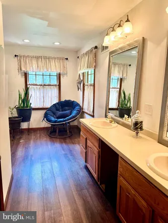a bathroom with a granite countertop sink mirror and window