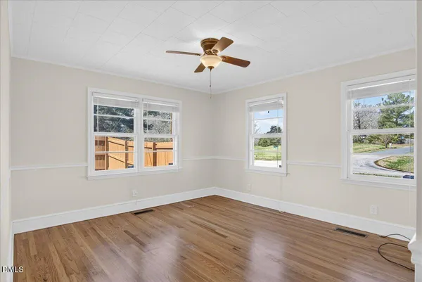 a view of an empty room with wooden floor