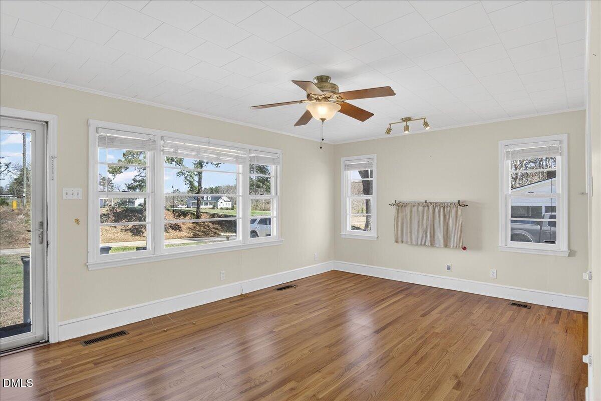 2118 Nutbush Road Henderson, NC 27537 - Photo 3 of 61 a view of an empty room with wooden floor and a window
