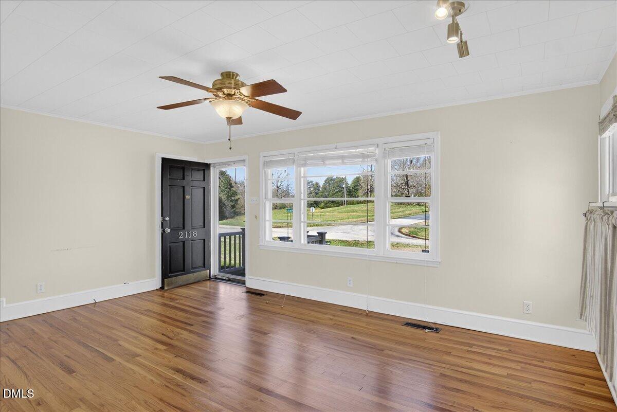 2118 Nutbush Road Henderson, NC 27537 - Photo 5 of 61 a view of an empty room with wooden floor and a window
