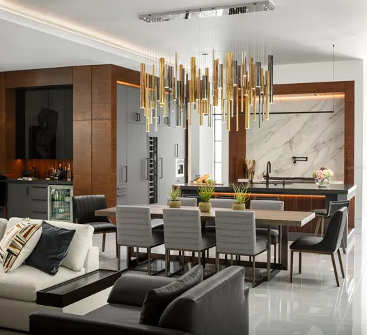 a living room with couches a large dining table and chairs with wooden floor