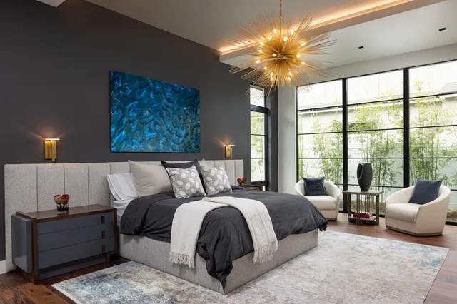 a bedroom with a large bed and a chandelier