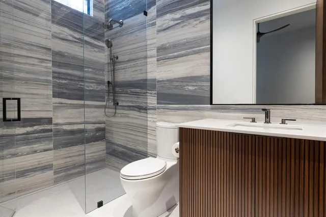 a bathroom with a sink a toilet and shower