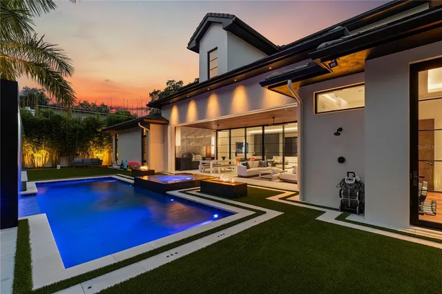 a view of swimming pool with chairs and table