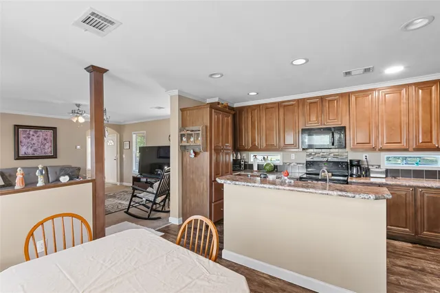 a kitchen with stainless steel appliances granite countertop a refrigerator a stove top oven a sink and dishwasher