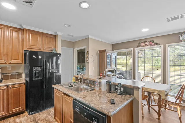 a kitchen with granite countertop a sink and a refrigerator