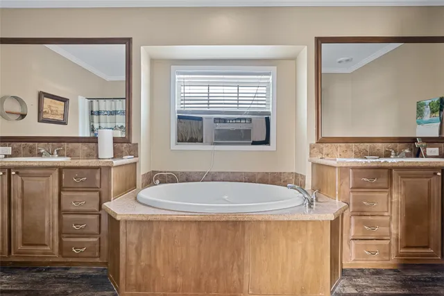 a bathroom with a granite countertop sink a mirror a vanity and a window