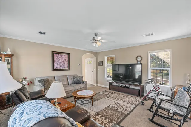 a living room with furniture a flat screen tv and a window