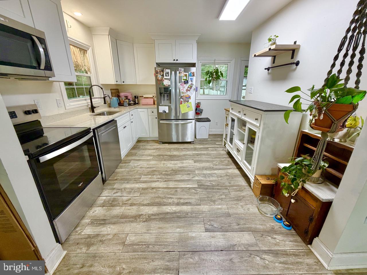 2413 Shelburn Road Millville, NJ 08332 - Photo 9 of 41 a kitchen with stainless steel appliances a stove top oven a sink a dining table and chairs