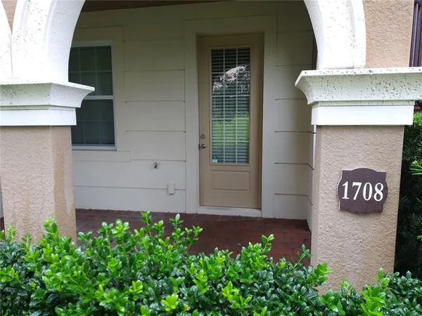 a view of front door of house and potted plants