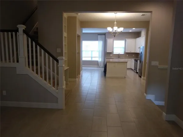 a view of a hallway with kitchen and dining table