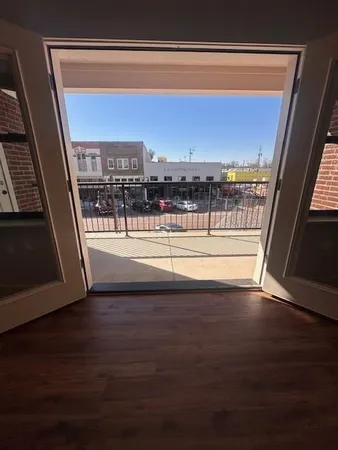 a view of a floor to ceiling window and an empty room with wooden floor