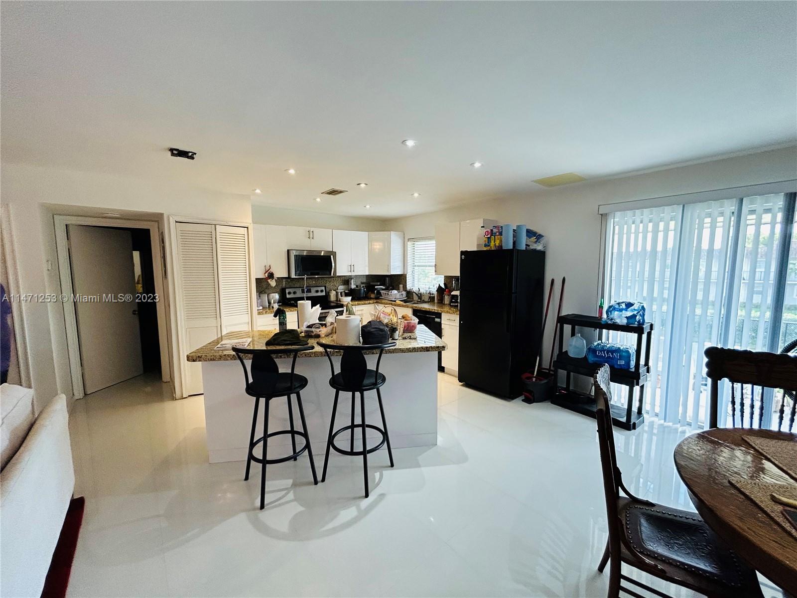 a living room with furniture and a dining table with refrigerator
