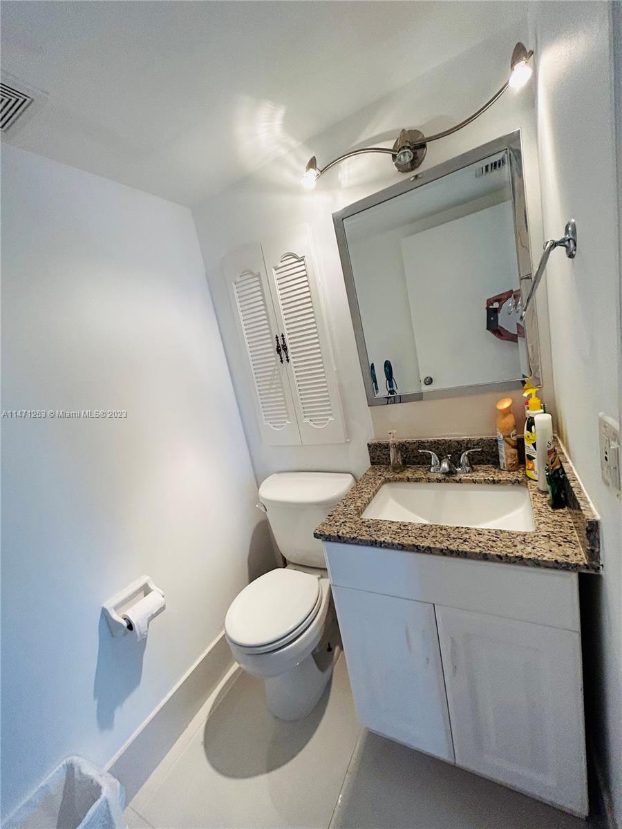22795 Southwest 66th Avenue, Unit 205 Boca Raton, FL 33428 - Photo 16 of 33 a bathroom with a granite countertop toilet sink and mirror