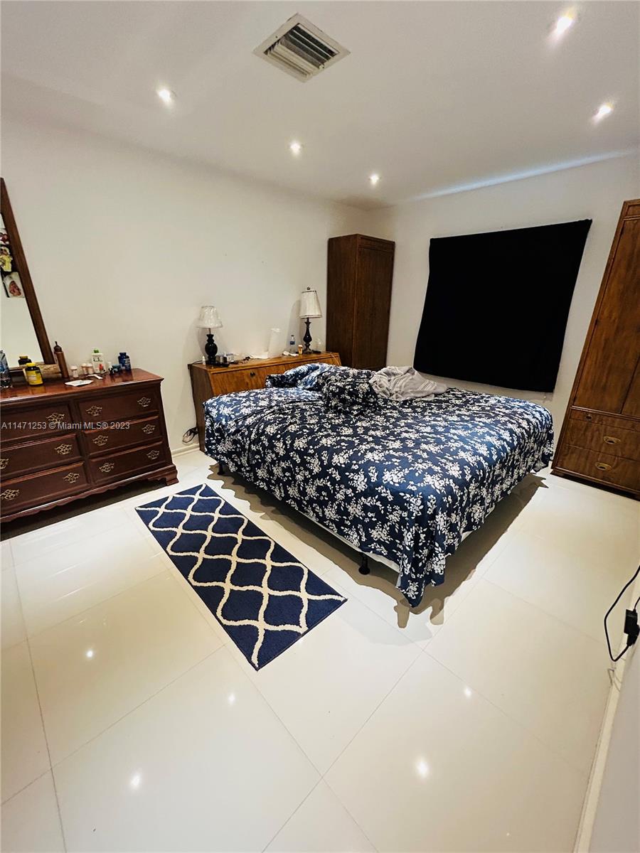 22795 Southwest 66th Avenue, Unit 205 Boca Raton, FL 33428 - Photo 19 of 33 a bedroom with bed and flat screen tv