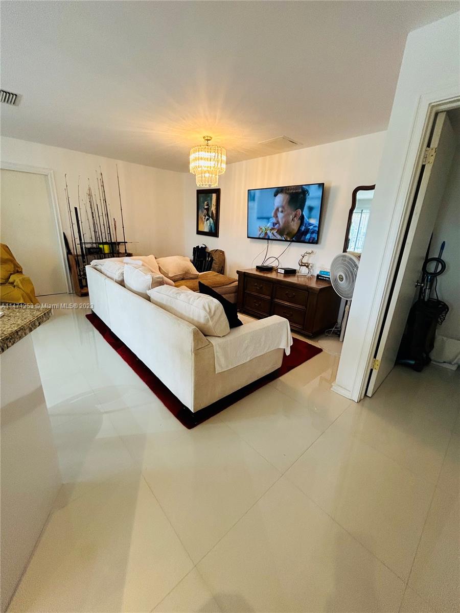 22795 Southwest 66th Avenue, Unit 205 Boca Raton, FL 33428 - Photo 2 of 33 a living room with furniture and a flat screen tv