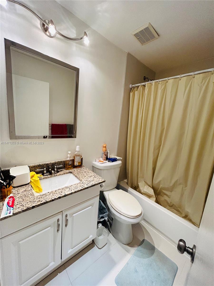22795 Southwest 66th Avenue, Unit 205 Boca Raton, FL 33428 - Photo 23 of 33 a bathroom with a granite countertop sink vanity mirror and toilet