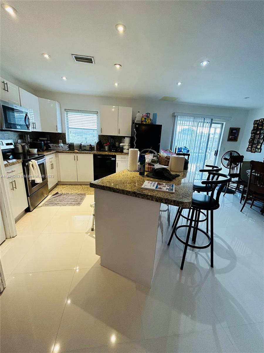 22795 Southwest 66th Avenue, Unit 205 Boca Raton, FL 33428 - Photo 6 of 33 a living room with stainless steel appliances kitchen island granite countertop furniture and a view of kitchen