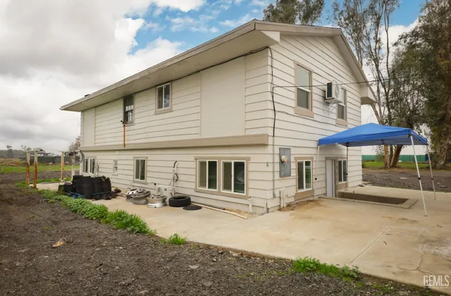 a backyard of a house with barbeque oven table and chairs