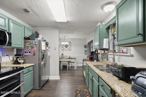 a kitchen with granite countertop a sink and cabinets