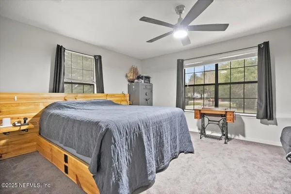 a bedroom with a bed and a large window with outer view