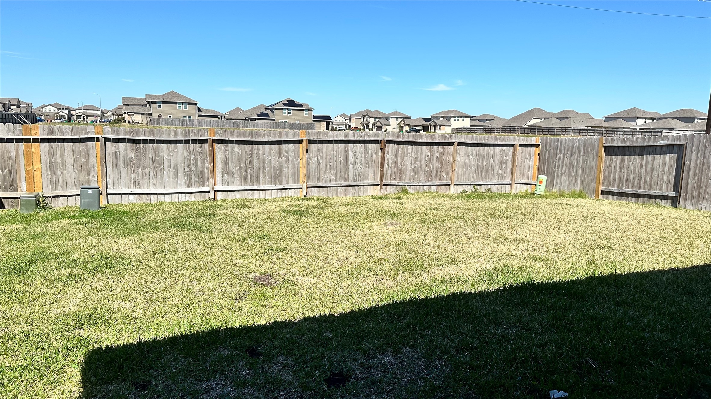 1103 Cattle Chute Court Rosharon, TX 77583 - Photo 26 of 26 Spacious fenced backyard with a grassy area, ideal for outdoor activities or gardening, offering privacy and views of neighboring homes.