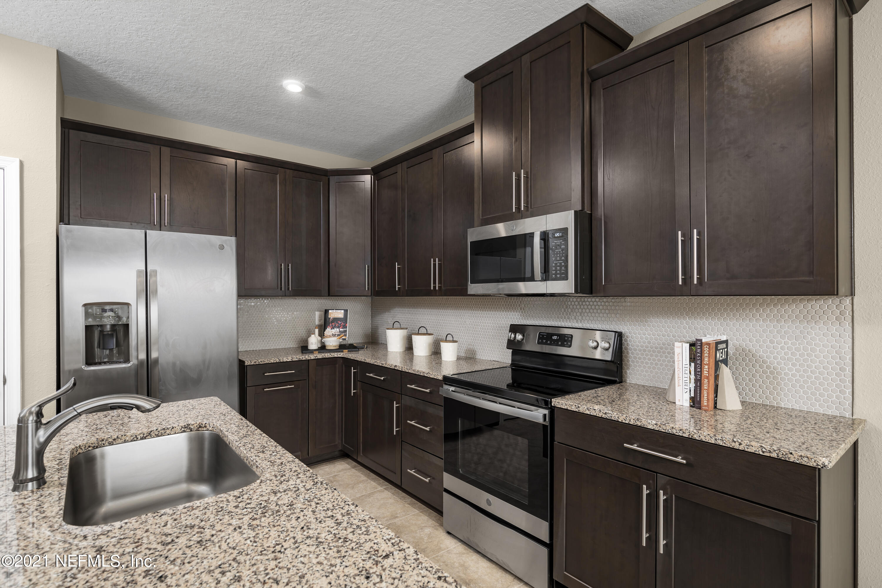 1339 Tan Tara Trail Jacksonville, FL 32221 - Photo 14 of 18 a kitchen with stainless steel appliances granite countertop a sink refrigerator and microwave